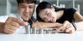 Happy Young Couple sitting with stacks of golden coins over table at home Royalty Free Stock Photo