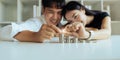 Happy Young Couple sitting with stacks of golden coins over table at home Royalty Free Stock Photo