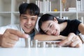 Happy Young Couple sitting with stacks of golden coins over table at home Royalty Free Stock Photo