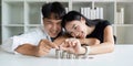 Happy Young Couple sitting with stacks of golden coins over table at home Royalty Free Stock Photo