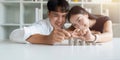 Happy Young Couple sitting with stacks of golden coins over table at home Royalty Free Stock Photo