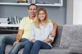 Happy young couple sitting on their couch Royalty Free Stock Photo