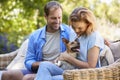 Happy young couple sitting with their pet dog in the garden Royalty Free Stock Photo