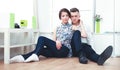 Happy young couple sitting together on the floor Royalty Free Stock Photo