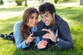 Happy young couple with smartphone at the park