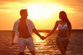 Happy young couple spending time  on sea beach at sunset Royalty Free Stock Photo