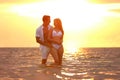 Happy young couple spending time  on sea beach at sunset Royalty Free Stock Photo