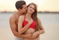 Happy young couple spending time together on  beach at sunset Royalty Free Stock Photo