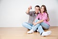 Happy young couple standing close to each other and smiling while holding key from the house Royalty Free Stock Photo