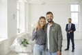 Happy young couple standing in their new house, smiling and showing the key to new home Royalty Free Stock Photo