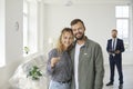 Happy young couple standing in their newly bought house, smiling and showing the keys Royalty Free Stock Photo