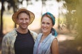 Happy young couple standing by trees at farm Royalty Free Stock Photo