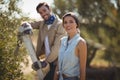 Happy young couple standing by trees at olive farm Royalty Free Stock Photo