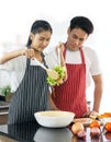 Happy young couple stay home together enjoy cooking fresh vegetable salad in kitchen for dinner. Royalty Free Stock Photo