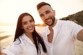 Happy young couple taking selfie on beach at sunset Royalty Free Stock Photo