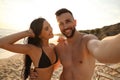 Happy young couple taking selfie on beach at sunset Royalty Free Stock Photo