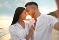 Happy couple taking selfie on beach at sunset Royalty Free Stock Photo