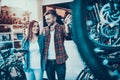 Happy Young Couple Talk about Wheel in Bike Shop