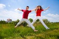 Happy Young Couple - team is jumping in the sky Royalty Free Stock Photo