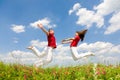 Happy Young Couple - team is jumping in sky Royalty Free Stock Photo