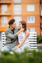 Happy young couple teenagers are sitting on the bench city in the summer sunny day Royalty Free Stock Photo
