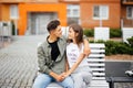 Happy young couple teenagers are sitting on the bench city in the summer sunny day Royalty Free Stock Photo