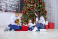 Happy young couple and their baby son opening gift boxes at Christmas tree Royalty Free Stock Photo