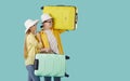 Happy young couple with their travel bags standing on turquoise copy space background Royalty Free Stock Photo