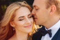 Happy young couple in their wedding day spend time in park. Green background Royalty Free Stock Photo