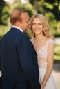 Happy young couple in their wedding day spend time in park. Green background Royalty Free Stock Photo