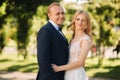 Happy young couple in their wedding day spend time in park. Green background Royalty Free Stock Photo