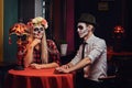 Young attractive couple with undead makeup during dating at a mexican restaurant.