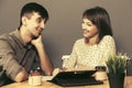 Happy young couple with digital tablet computer sitting at the table Royalty Free Stock Photo