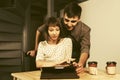 Happy young couple using digital tablet computer sitting at the table Royalty Free Stock Photo