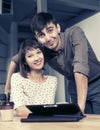 Happy young couple using digital tablet computer sitting at the table Royalty Free Stock Photo