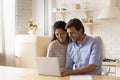 Happy young couple using laptop in modern kitchen together Royalty Free Stock Photo