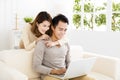 Happy young couple using laptop on sofa Royalty Free Stock Photo