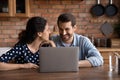 Happy young couple using laptop together in modern kitchen Royalty Free Stock Photo