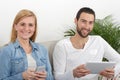 Happy young couple using tablet and phone Royalty Free Stock Photo