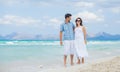 Happy young couple walking on beach