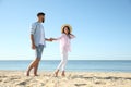 Happy couple walking on beach near sea. Honeymoon trip Royalty Free Stock Photo