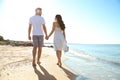 Happy couple walking on beach near sea. Honeymoon trip Royalty Free Stock Photo