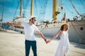 Happy young couple walking by the harbor of a touristic sea resort Royalty Free Stock Photo