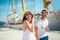 Happy young couple walking by the harbor of a touristic sea resort Royalty Free Stock Photo