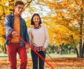 Young couple walking outdoors in autumn park with dogs Royalty Free Stock Photo