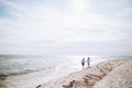 Happy young couple walking on the sea beach holding hands. Summer vacation Royalty Free Stock Photo
