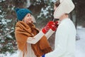 Happy young couple walking in winter snowy forest in warm knitted gloves Royalty Free Stock Photo