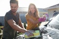 Happy young couple washing car at backyard Royalty Free Stock Photo