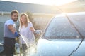 Happy young couple washing car at backyard Royalty Free Stock Photo