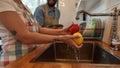 Happy young couple washing vegetables in the kitchen while preparing ingredients for dinner. Cooking at home concept Royalty Free Stock Photo